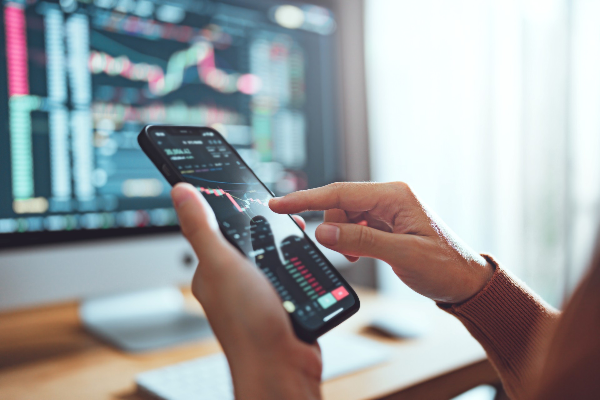 Woman is checking Bitcoin price chart on digital exchange on smartphone, cryptocurrency future price action prediction.